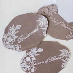 three personalized coasters with flowers on them sitting on top of a white table