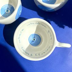 two blue and white bowls sitting next to each other on a blue tableclothed surface