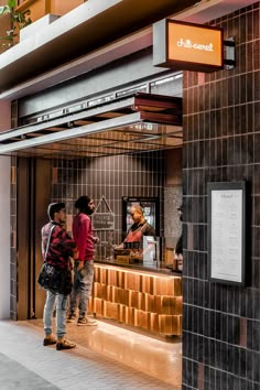 two people standing in front of a restaurant counter