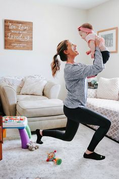 a woman is playing with her baby in the living room