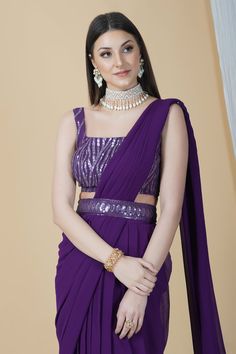 Get ready to leave everyone awestruck with your grace by adorning this ready to wear saree in a dreamy purple hue. With a belt running across and a tie-knot at back, this saree can be perfectly worn for an engagement or a cocktail party.Style Ready to Wear Saree with an embellished belt Dreamy Purple hue Sequins blouse Georgette fabric Specifications Model height - 5'9" Model wearing - S Purple Embellished Pre-draped Saree, Embellished Purple Pre-draped Saree, Elegant Purple Pre-draped Saree, Purple Embellished Georgette Pre-draped Saree, Pre-draped Purple Saree With Mirror Work, Purple Floor-length Pre-draped Saree For Reception, Purple Georgette Pre-draped Saree For Evening, Elegant Purple Choli With Traditional Drape, Traditional Purple Pre-draped Saree For Party