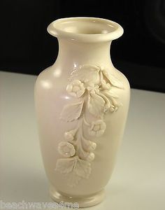 a white vase sitting on top of a table