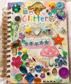 a spiral notebook covered in lots of different items and words, including buttons, beads, stars, and other things