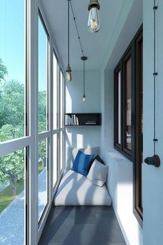 a white couch sitting on top of a window sill next to a book shelf