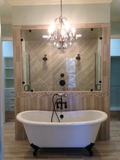 a bathroom with a claw foot tub and chandelier in the middle of it