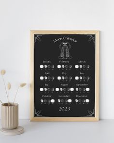 a chalkboard with the names and dates for each month in front of a vase