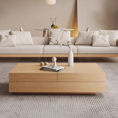 a living room filled with white couches and wooden coffee table in front of a beige wall