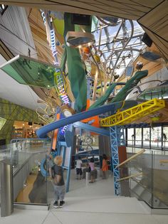 the inside of a building with people standing around and looking at artwork on the walls