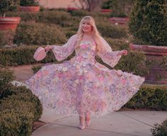 a woman with blonde hair wearing a dress and holding a frisbee in her hand