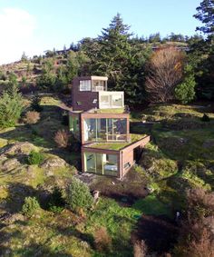 three small houses sitting on top of a lush green hillside