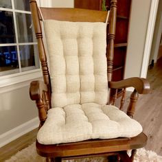 a wooden rocking chair sitting on top of a rug