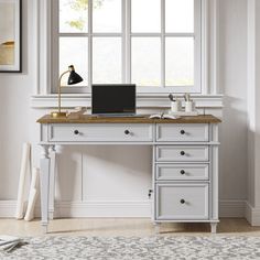 a white desk with a laptop on it in front of a large window and rug