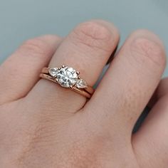 a person's hand with a gold ring and two diamonds on top of it