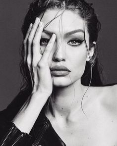 a black and white photo of a woman holding her hands to her face with one hand