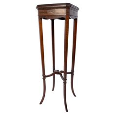 an antique wooden table with two legs and a drawer on the top, sitting against a white background