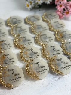 wedding favors with gold glitter on them and name tags for each guest's place