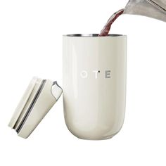 a white coffee mug being filled with red wine