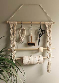 a wall hanging on the side of a white wall with scissors and other items attached to it