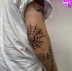 a man with a spider web tattoo on his arm