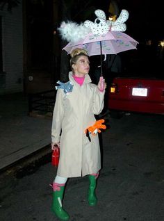 a woman dressed in rain gear holding an umbrella