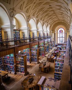 the interior of a library with many tables and bookshelves full of books in it