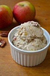 an ice cream dish with pecans and apples in the background