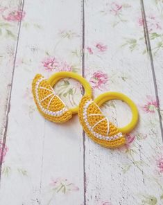 two crocheted oranges are sitting next to each other on a wooden surface