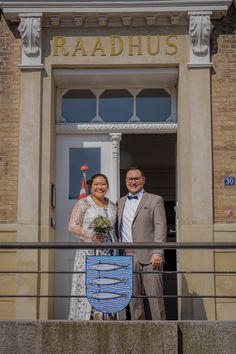 a man and woman standing in front of a building