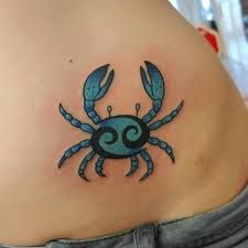 a woman's stomach with a blue crab tattoo on it