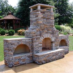 an outdoor stone pizza oven in the middle of a yard