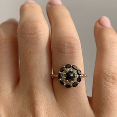 a woman's hand with a black and white diamond ring on top of it