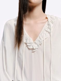 MO&Co. Women's Loose Ruffled Trim Blouse Crafted from a blend of cotton and silk, this blouse features billowy sleeves with delicate ruffled cuffs and a V-neckline with a self-tie design. The loose silhouette pairs perfectly with high-waisted jeans for a chic, effortless look. Features : - Flowy regular fit- Volume sleeves with ruffled cuffs- V neckline with self-tie straps and ruffles details- Made a silk and cotton fabric, slightly sheer effect Code: MBD1TOP026The back length of size S is 68.5cmMATERIALS & CARE Material: 63.9% Cotton 36.1% SilkREMINDER: All items are measured manually. Please note that it's reasonable that there might be minor measurement differences (1-2cm) on some items. Volume Sleeves, Billowy Sleeves, Tie Design, Blue Blouse, Cuff Sleeves, High Waist Jeans, Ruffles, Shirt Blouses, Cotton Fabric