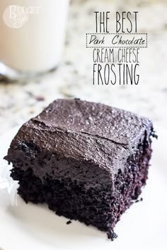 a piece of chocolate cake sitting on top of a white plate next to a glass of milk