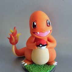 an orange toy sitting on top of a green patch of grass next to a white wall