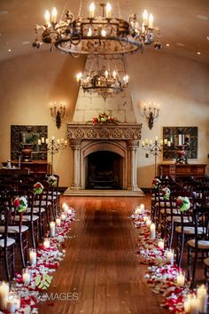 a room filled with lots of chairs covered in flowers and candles next to a fire place