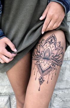 a woman's thigh with a tattoo on it and a flower in the middle