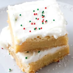 two pieces of cake with white frosting and sprinkles on a plate