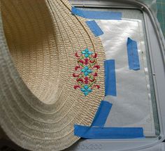 a straw hat sitting on top of a table next to a piece of paper and scissors