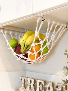 there are bananas, oranges and apples in a basket on the kitchen wall shelf