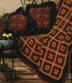 a crocheted blanket sitting on top of a chair next to a potted plant