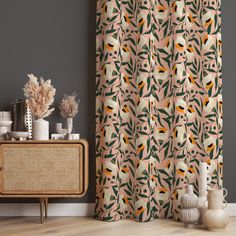 a curtain with an orange and yellow bird on it in front of a grey wall