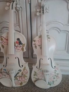 two white violin's with floral designs on them