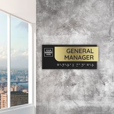 there is a sign that says general manager on the wall in front of a window