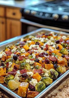 a baking pan filled with brussel sprouts and other vegetables on top of a counter