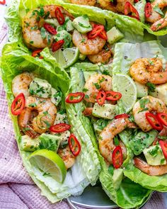 two lettuce wraps filled with shrimp and garnished with lime wedges