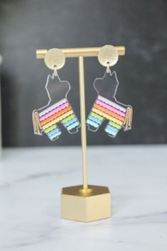 These pinata earrings will make ANY outfit more festive! Get ready to celebrate Cinco de Mayo in style. Everyone is going to ask where you got these fun earrings! Made from lightweight acrylic. Available in 2 options:  * Clear Acrylic with a Rainbow of Colors  * Iridescent Acrylic   They hang from matte gold 18k gold plated coin studs with a stainless steel earring post. Customers with sensitive ears always tell us that our earrings are great! Novelty Multicolor Earrings For Birthday, Cute Plastic Party Earrings, Plastic Drop Earrings For Party, Multicolor Plastic Earrings For Party, Fun Plastic Jewelry For Party, Fun Plastic Party Jewelry, Idea Lab, Iridescent Acrylic, Acrylic Ideas