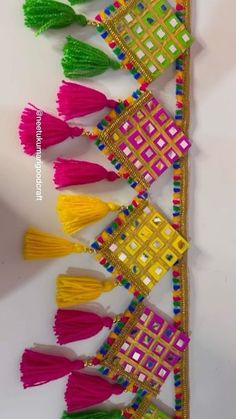 colorful tassels are lined up on a white surface