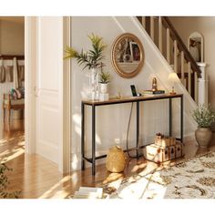 an entryway with a table, potted plants and other items on the floor