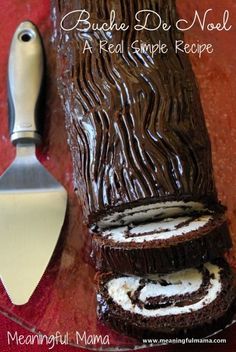 there is a chocolate roll with white frosting next to a spatula