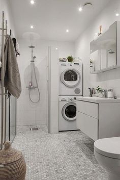 a washer and dryer in a white bathroom with tile flooring on the walls